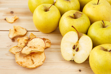 Dried and fresh apples on a wooden background