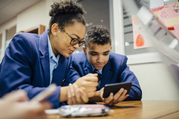 Sneaky Students Using Smartphone In Lesson