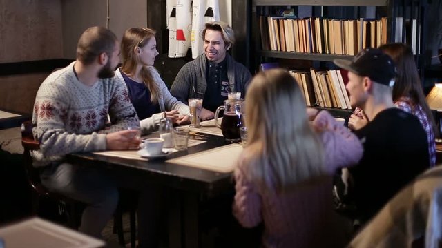 Six hipster student friends communicating in cafe
