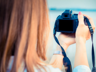 Asian Woman using a camera, camera with blank screen. On a sunny days.