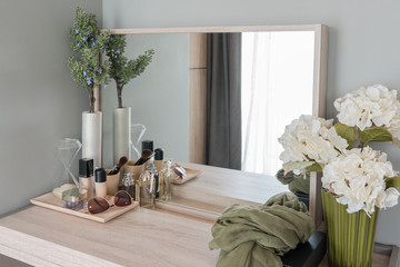 Beauty and make-up concept: table mirror, flowers, perfume, jewe
