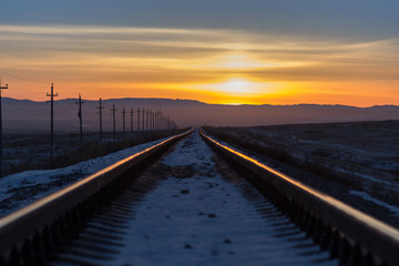 Fototapeta premium Railway receding into the distance at sunrise