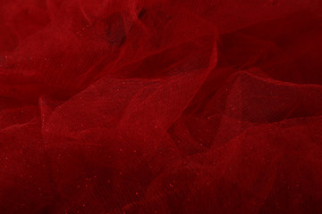 Red tulle fabric background. Abstract transparent material curve wave.