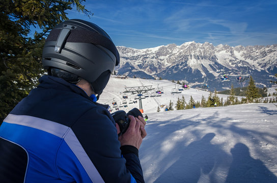 Photgrapher skiing in the alps of austria and taking pictures
