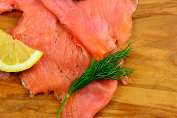 Fischkarte - Räucherlachs mit Dill und Zitrone am Holzbrett mit Textfreiraum