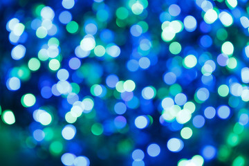 Naklejka na ściany i meble Blurred lights blue background. Glittering christmas effect. Abstract colorful pattern. Shimmering blur spots. Festive design.