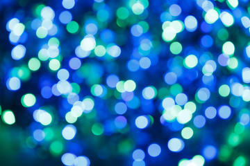 Blurred lights blue background. Glittering christmas effect. Abstract colorful pattern. Shimmering blur spots. Festive design.