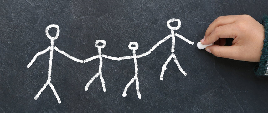 Enfant dessinant une famille &agrave; la craie sur une ardoise