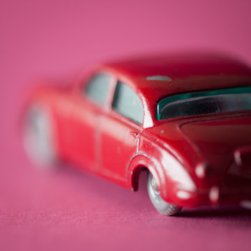 English car toy on fuchsia background