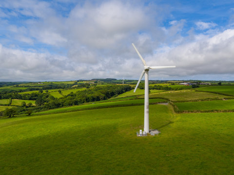 aerial view of a electricity generating wind turbine in green field
