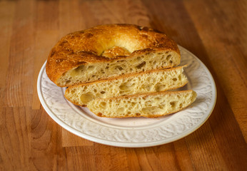 Naan bread on a wooden table. Top view. Fresh fragrant crispy bread. 
Sliced tandoor bread on cutting board closeup. Slices of home-made bread on an old background. Orient, asian, indian cuisine.