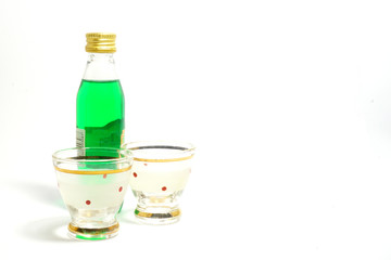 Small bottle of mint liqueur with two shot glasses