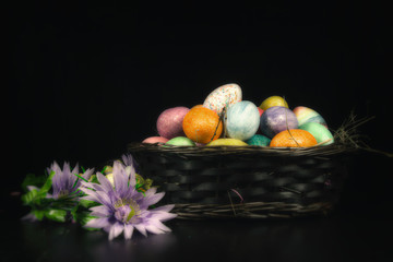 Easter Basket Spring Flowers. Easter basket and Spring flowers on a dark rustic table.