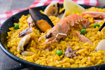 Traditional spanish seafood paella on wooden background
