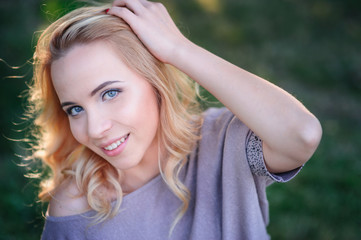 Naklejka premium beautiful young woman with make-up posing in a summer park