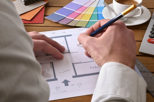 Designer writing on the plan of an interior design project