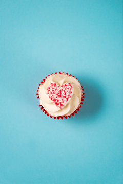 Overhead Of Cupcake In Red Wrap With Heart-Shaped Candy