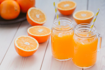Fresh orange juice in a mason jar and orange sliced ripe on wooden table. Healthy eating concept.
