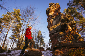 Wanderer ist beeindruckt von einer markanten Sandstein- Formation im Pfälzer Wald / Napoleonshut,...