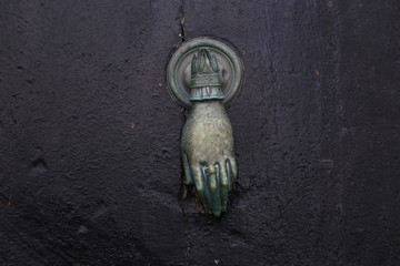Metal door knocker in the shape of a female hand in korsika