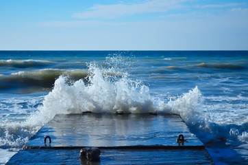 Sea waves crashing against the concrete pier