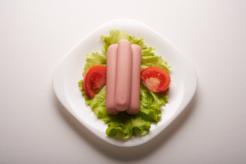 sausages with vegetables on a white background