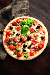 Delicious hot  pizza with salami, pepperoni and cheese on a dark