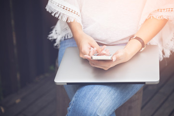 Close up young woman using mobile smartphone and laptop, People with technology lifestyle