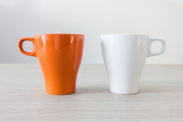 Orange and white  cup on wooden table isolate on white background