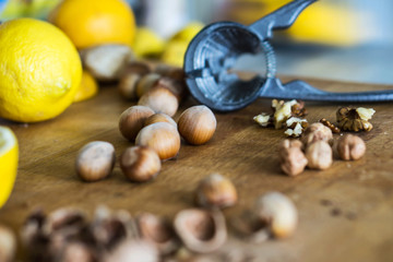 Closeup of whole and broken hazelnuts, lemon, walnut and nutcrac
