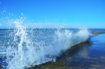 Sea waves crashing against the concrete pier