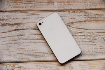 Smartphone on wooden table on light background