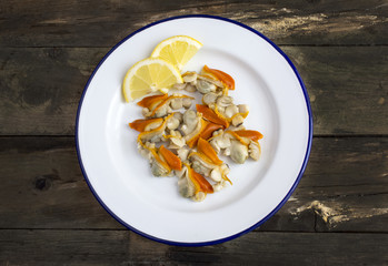 
Natural clams with lemon served on a plate