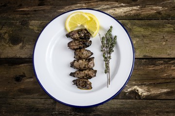 Squid in its ink served on a plate with lemon and thyme