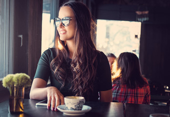 Smiling brunette woman in a cafe.
