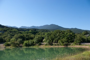 Fototapeta na wymiar green lake in the mountains near the green hills