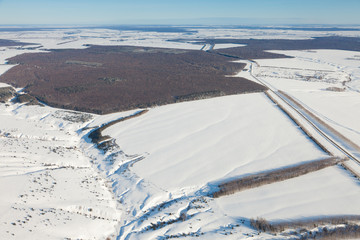 Obraz premium aerial view over snowy field and road