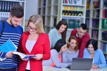 Two young students working together at the library