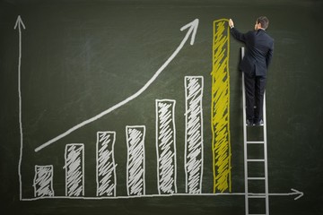 Successful businessman is standing on ladder and drawing growing graph of profit on blackboard....