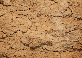 the texture of the clay , the cracks on the surface of the earth , the background is yellow