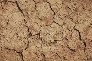 the texture of the clay , the cracks on the surface of the earth , the background is yellow