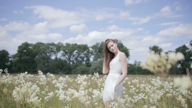 Young pretty woman in the middle of flower meadow