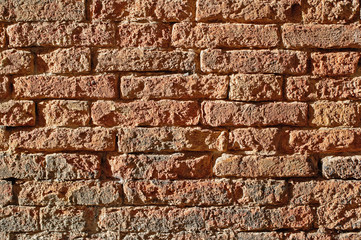 Texture of sun bright old red brick wall