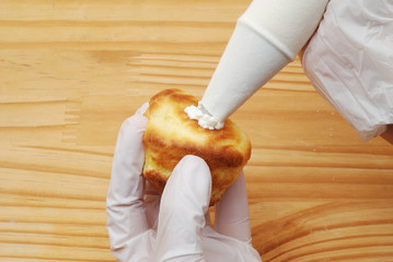 Cream puffs filled with cream with pastry bag