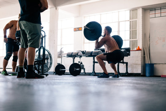 Bodybuilder exercising with heavy weights at crossfit gym