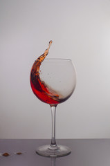 splash of red wine in a round glass