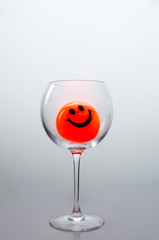 Orange ball with a smile in the glass