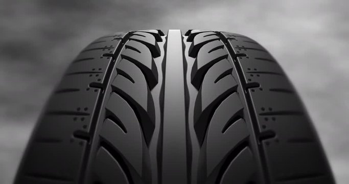 Close up car tire rotating slowly with depth of field and foggy background