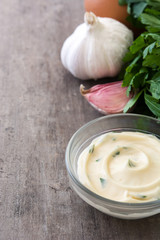 Aioli sauce and ingredients on wooden background
