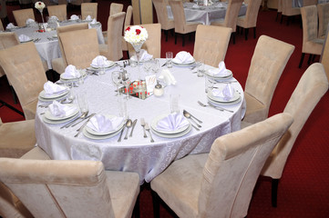 Cutlery with colorful flowers, jewelry and scented candles are placed at round tables for the guests traditional weddings, Novi Sad, Serbia